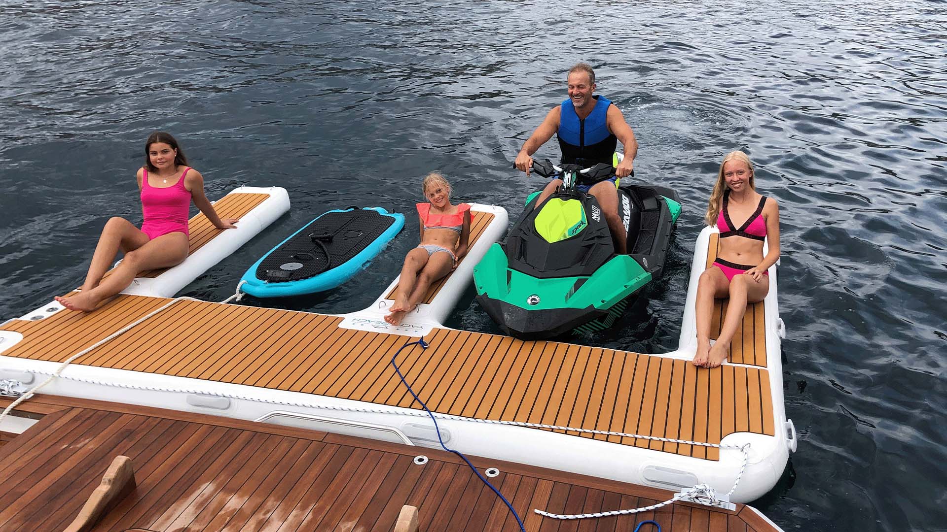 Das Bild zeigt ein Yacht Beach Jet Ski Dock auf dem Wasser mit Personen darauf.