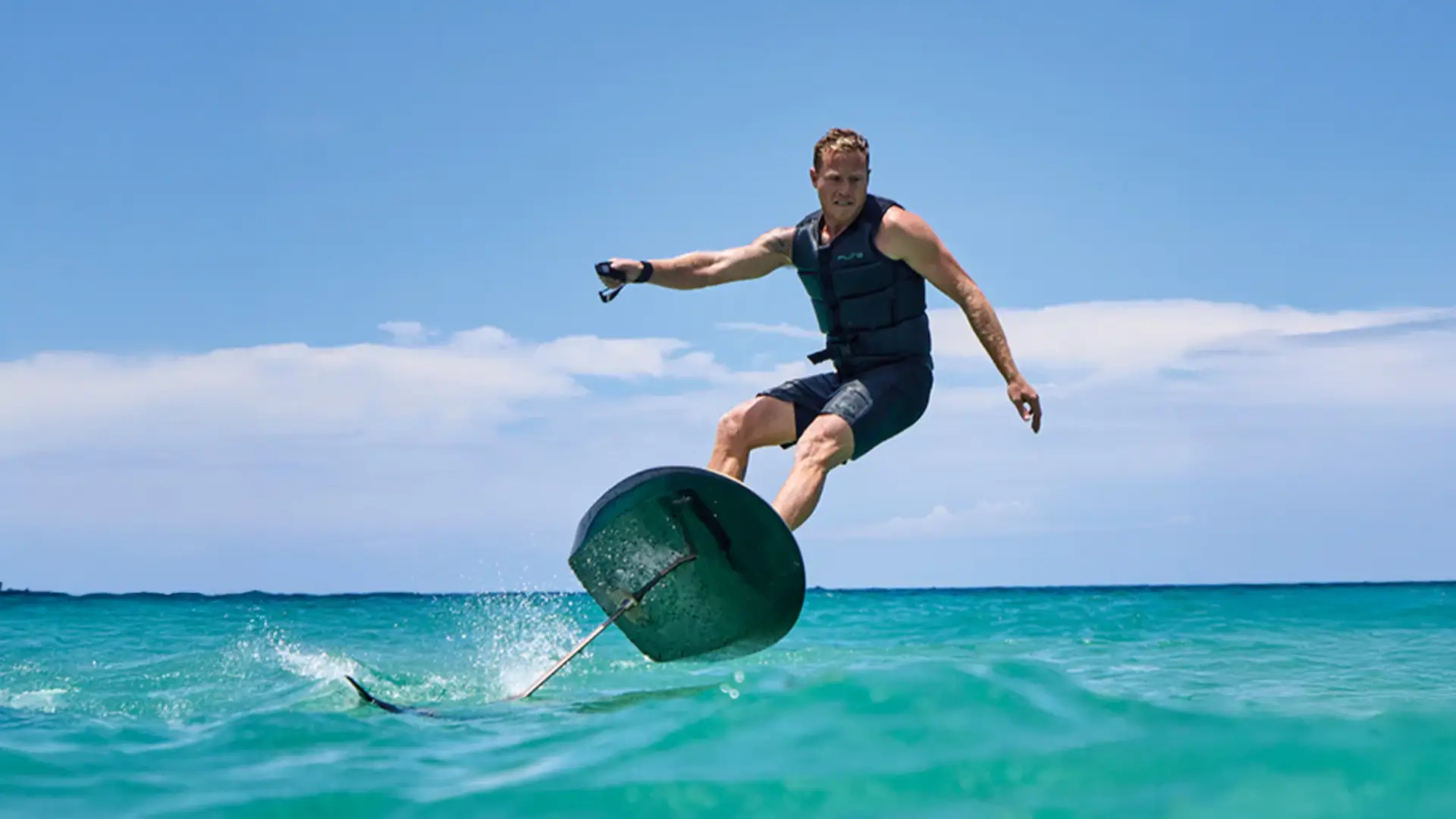 Ein Mann macht eine steile Kurve mit einem Fliteboard auf dem Meer.