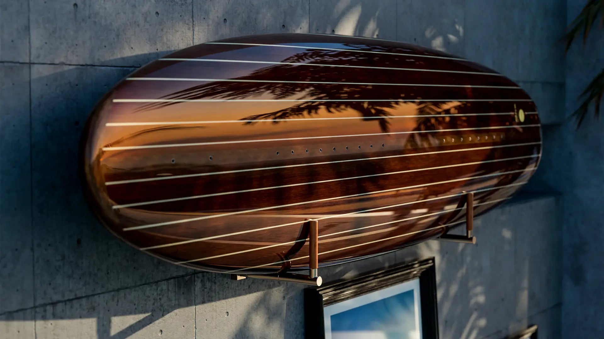 Ein Lind Surfboard mit Holzoptik hängt an einem Ständer an der Wand und wird von der Sonne beleuchtet.