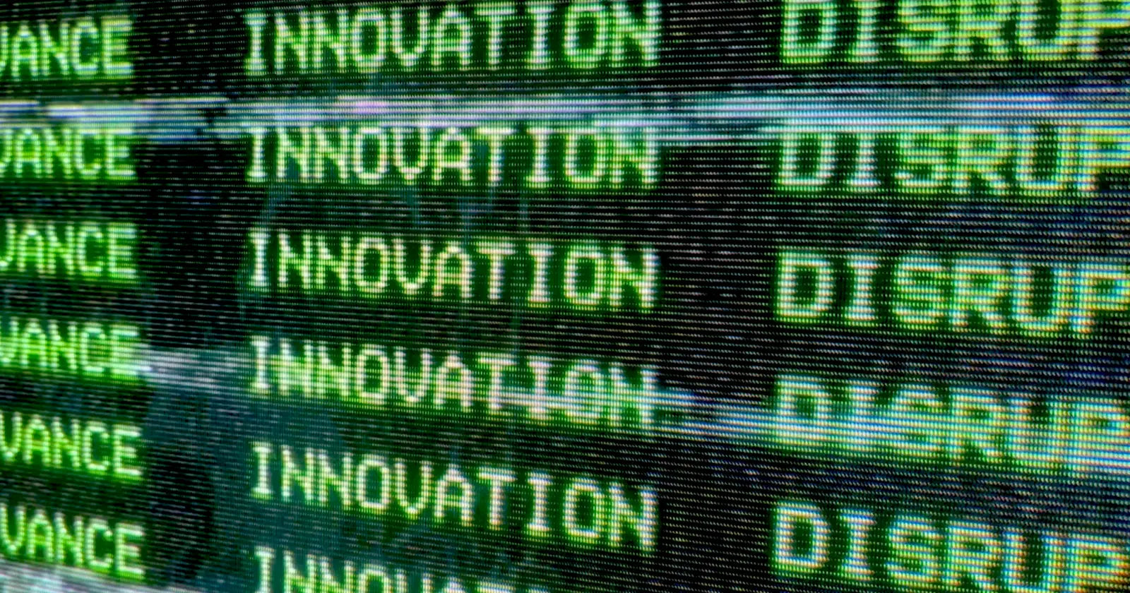 Nahaufnahme einer digitalen Anzeige mit den abwechselnden Worten "INNOVATION" und "DISRUPTIVE" in grüner Schrift.