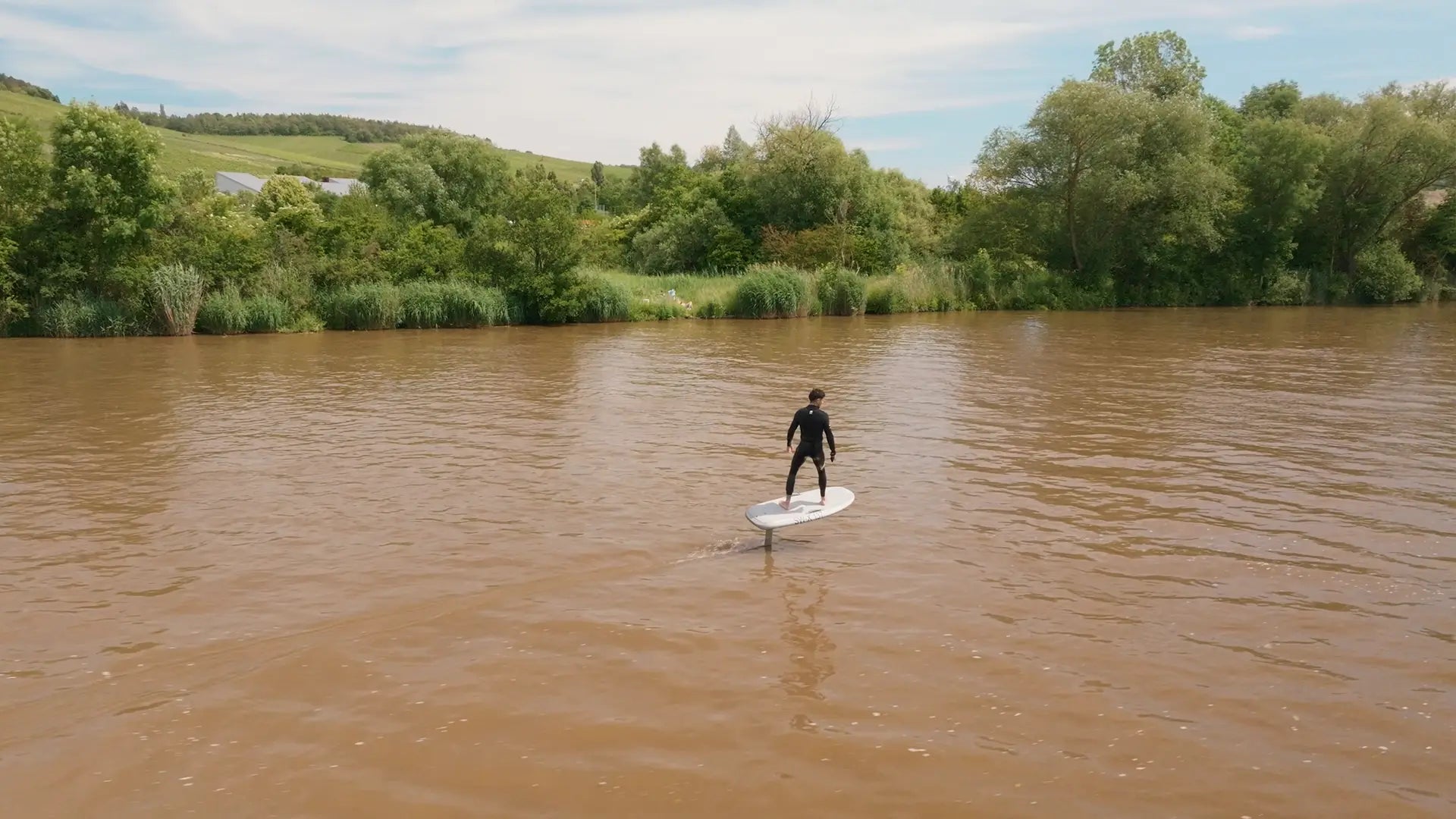 Eine Person foilt mit einem Fliteboard auf einem Fluss in Deutschland.