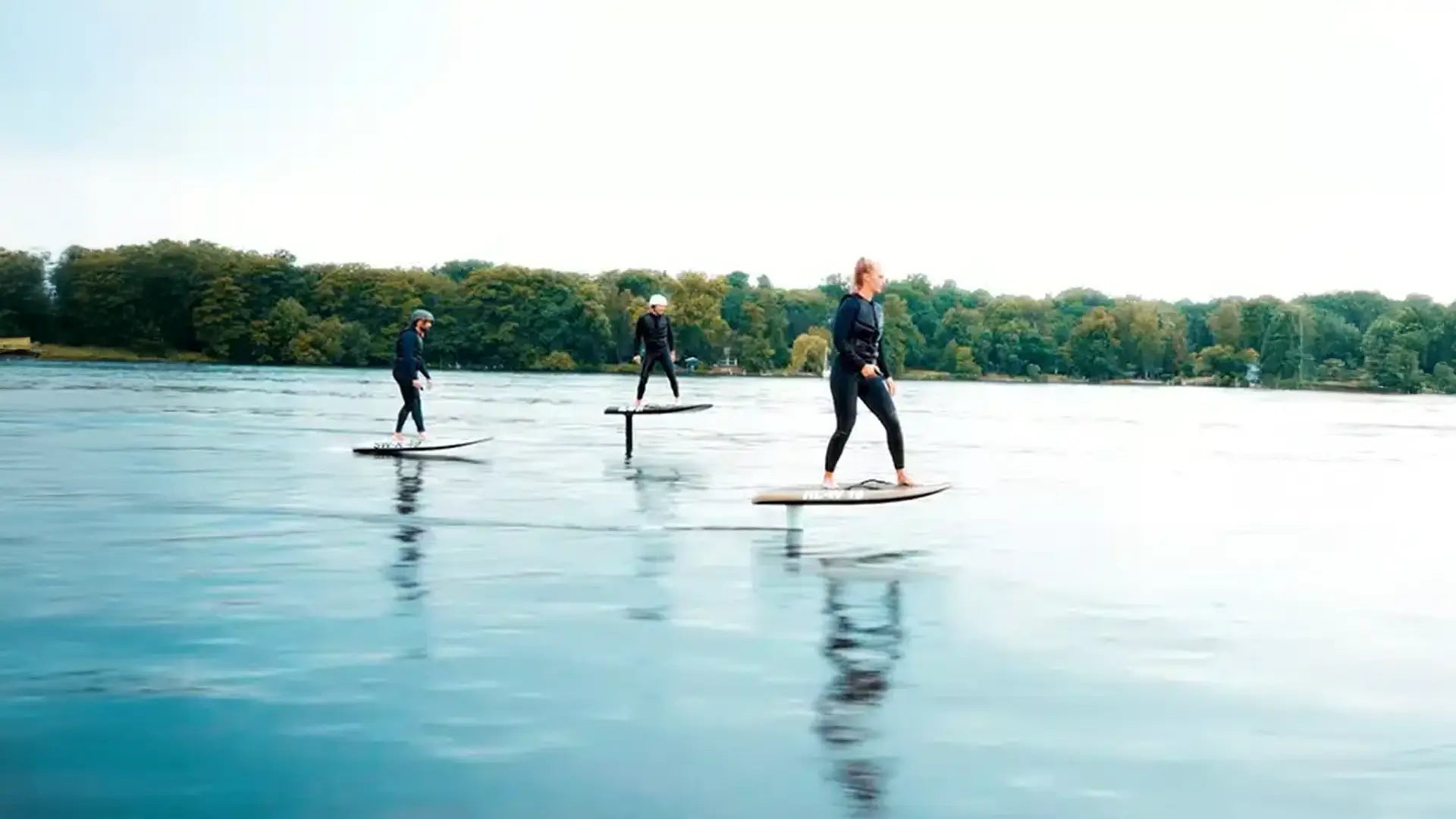 Drei Leute fahren mit ihren Fliteboards auf dem Wasser.
