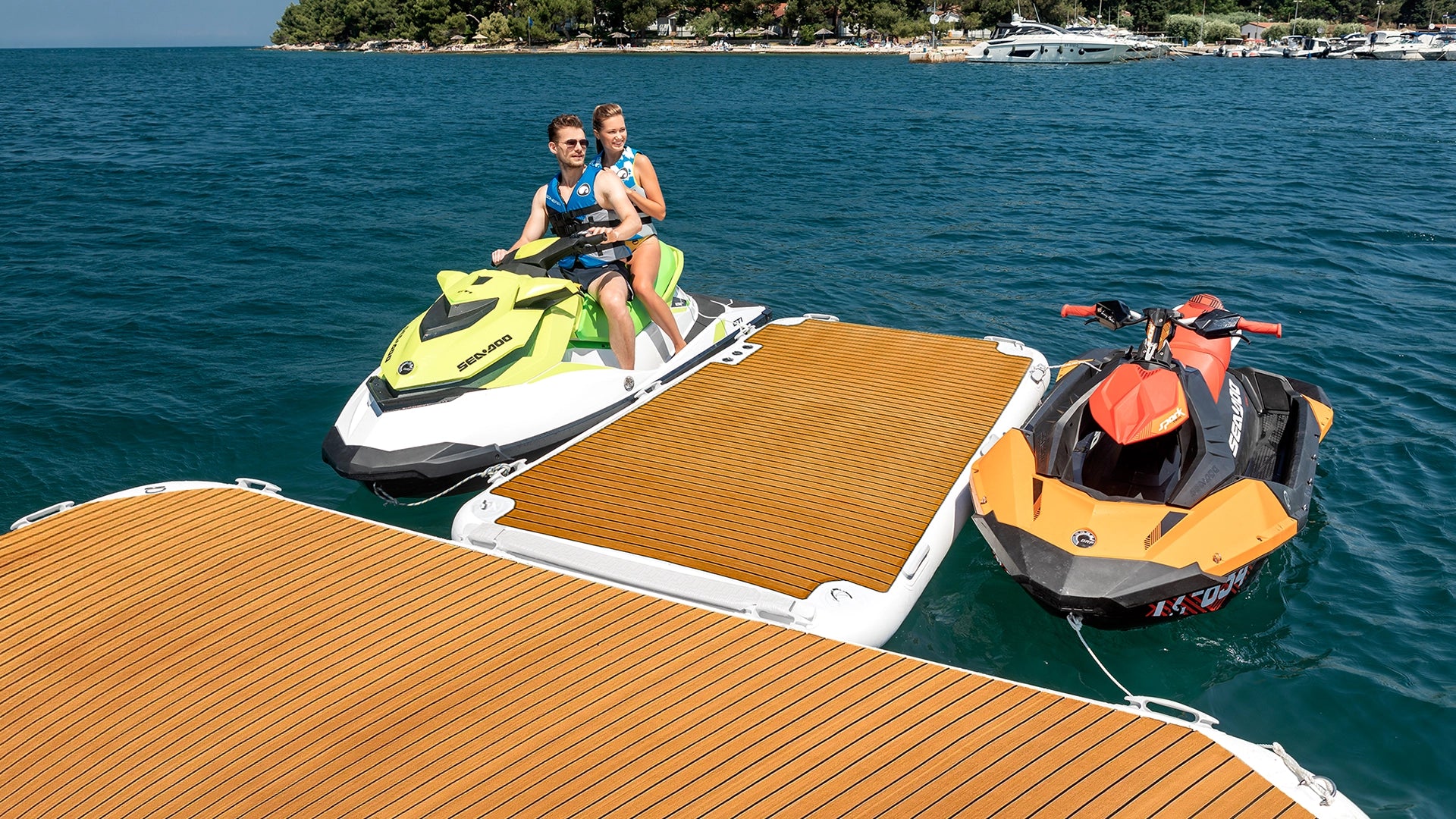Zwei Jet-Skis sind auf beiden Seiten des Yachtbeach Jet-Ski Docks auf dem Wasser geparkt.
