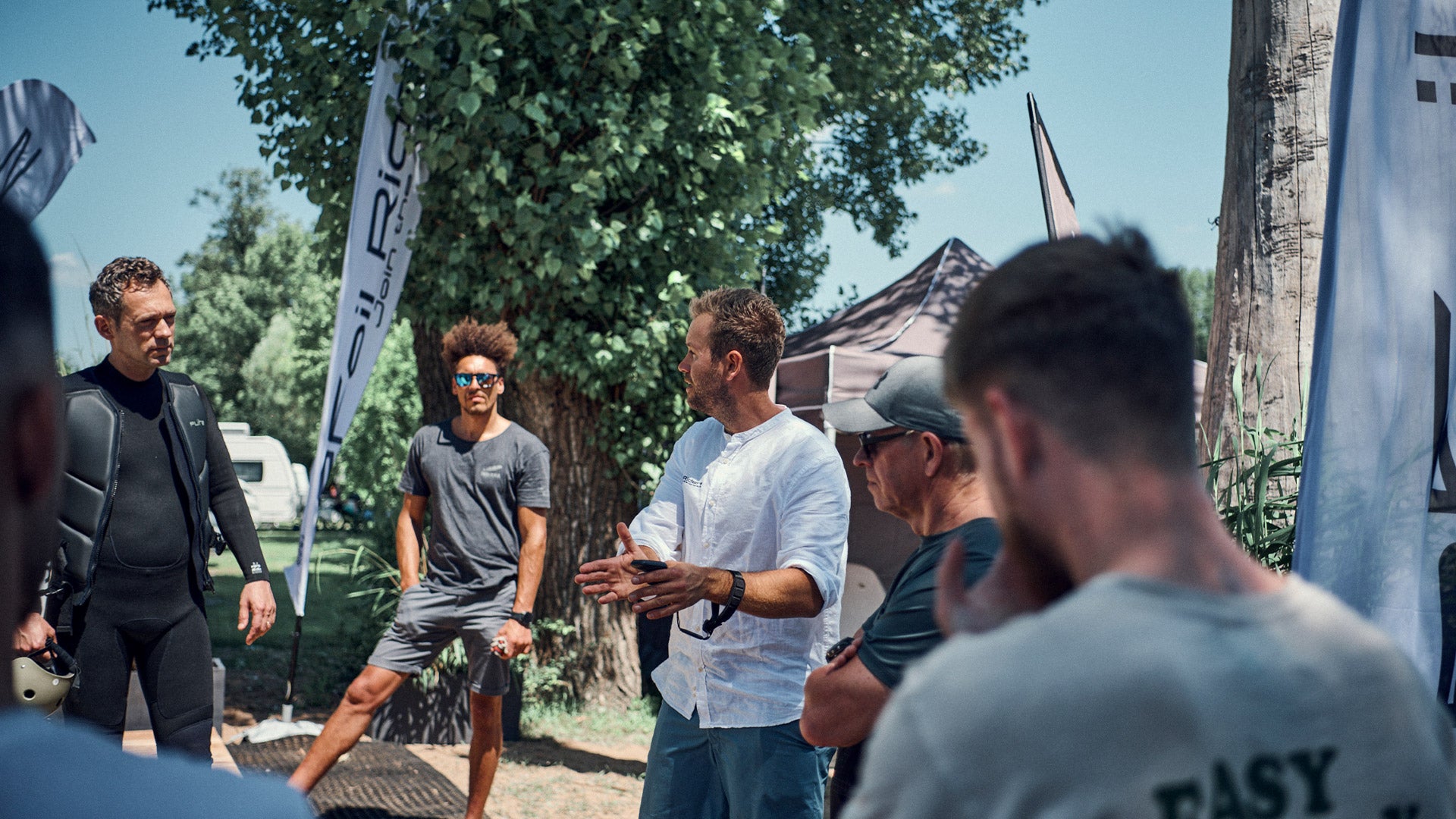 Ein eFoil Riders Surflehrer gibt fünf Personen eine Einweisung in die Benutzung der Fliteboards.